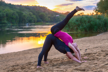 Fototapeta premium Fit young women performing acrobatics yoga