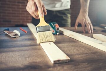 Brush in hand and painting the wood