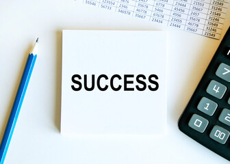 Finance and business concept. The businessman has on his desk graphs with reports, a notebook, a magnifying glass and a document with the inscription - SUCCESS