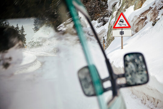 Winter snow warning, Slippery road in the snow road sign, Alps mountains, Switzerland, Europe