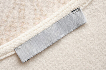 White blank laundry care cloth label on fabric texture background