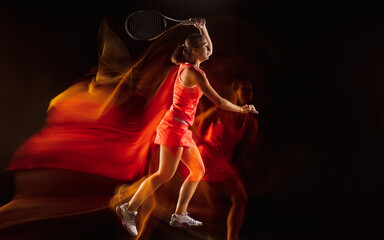 Champion. Professional female tennis player training isolated on black studio background in mixed light. Woman in sportsuit practicing. Healthy lifestyle, sport, workout, motion and action concept.