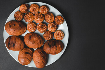 Cupcakes of different sizes on a black background with space for text.