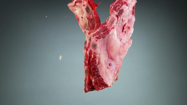 Flying piece of raw pork ribs hitting up in the air. Filmed on high speed cinema camera, 1000 fps.
