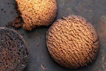 Burnt cookies. Burnt, burnt oatmeal cookies lie on a black baking sheet.