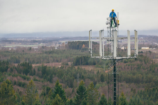 Working at heights, technician climbs up on a communications tower