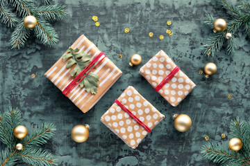 Christmas tree twigs gift boxes wrapped in recycled craft paper on dark turquoise background.