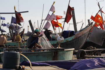 Fishermen repairing nets on a boat trip out to sea in the afternoon July 31, 2014 at the beach of Hai Ly, Vietnam.