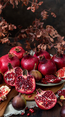 
Fresh juicy pomegranate - whole and cut, with leaves on a wooden  background