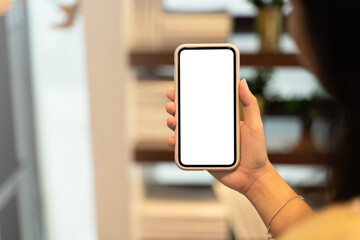 Woman hand's holding empty screen mobile phone at cafe.