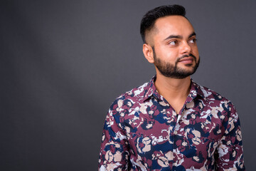 Obraz premium Young bearded Indian man against gray background