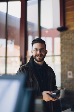 Smiling man using a debit machine