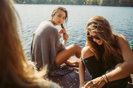 A group of friends are hanging on the dock during a summer afternoon