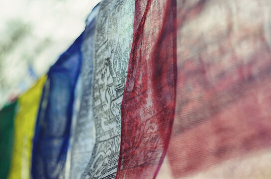 Closeup of a line of Buddhist prayer flags with mantras