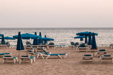 empty beach, with hammocks and parasols, cloudy day