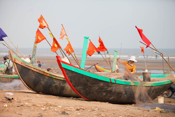 Fishermen repairing nets on a boat trip out to sea in the afternoon July 31, 2016 at the beach of...