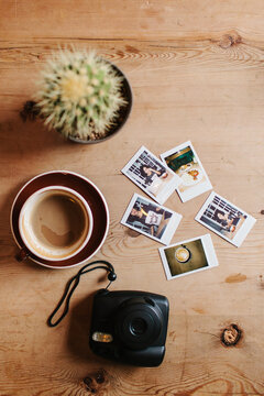 An instant camera and film laying on a coffee table