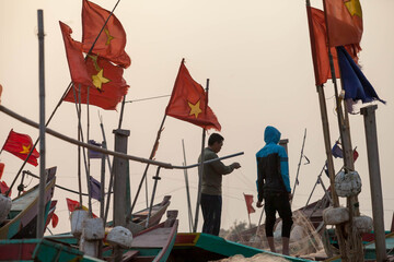 Fishermen repairing nets on a boat trip out to sea in the afternoon July 31, 2014 at the beach of...