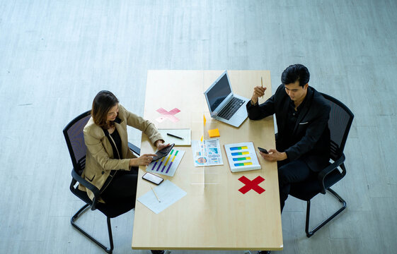 Business Man Working Apart From Colleague  In The Office. New Normal Social Distancing Concept.