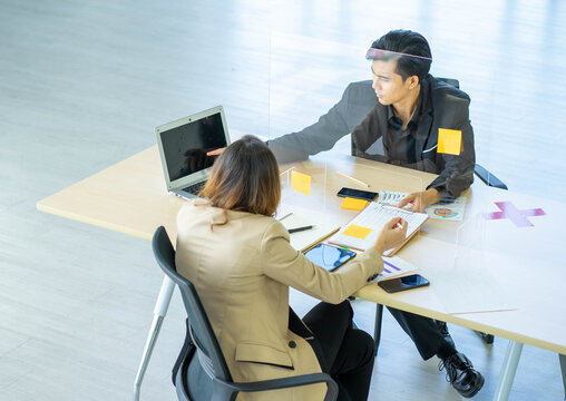 Business Man Working Apart From Colleague  In The Office. New Normal Social Distancing Concept.