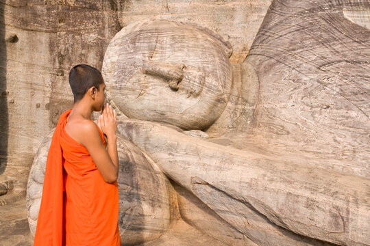 Monk praying at a rock-cut image of the Buddha in the Gal Vihara, Polonnaruwa (Polonnaruva), UNESCO World Heritage Site, Sri Lanka, Asia
