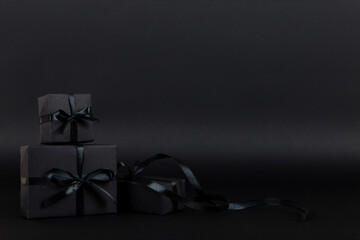Fototapeta na wymiar Black gift paper black background. Dark concept, sales. Copy space.