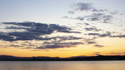 The sun set behind the mountains and the lake