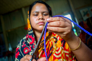 A woman crafts maker is making a showpiece home from the fibers of a banana tree at Madhupur,...
