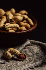 peanuts in a wooden plate on a black background