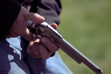 Man holding 19th century replica firearm.