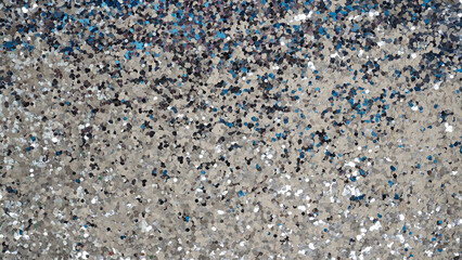 Beautiful sparkling silver background from large glitter for the design of cards for Christmas and New Years. Glittering texture, bokeh.Close-up