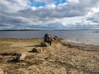 row of stones on the lake shore, male silhouette