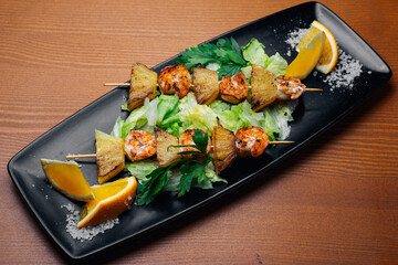 tiger prawns with pineapples in a black plate