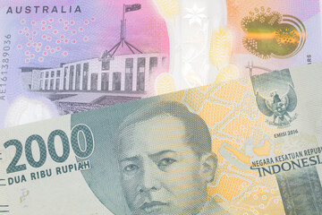 A macro image of a grey two thousand Indonesian rupiah bank note paired up with a colorful five dollar bill from Australia.  Shot close up in macro.