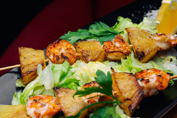 tiger prawns with pineapples in a black plate