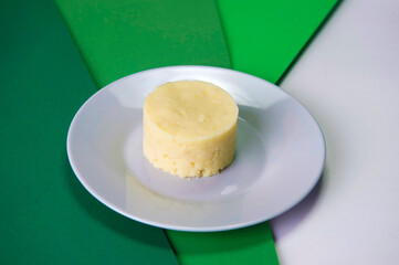 Mashed potatoes on gray plate served in culinary ring. Restaurant food menu garnish on green background. Single Warm Side dish.
