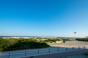 A View of a Beach With a Wooden Fence and Sand Dunes Covered in Plants in Wildwood New Jersey
