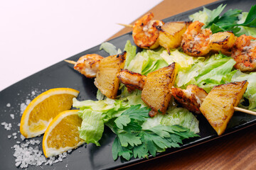 tiger prawns with pineapples in a black plate
