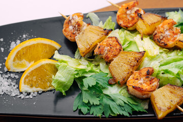 tiger prawns with pineapples in a black plate