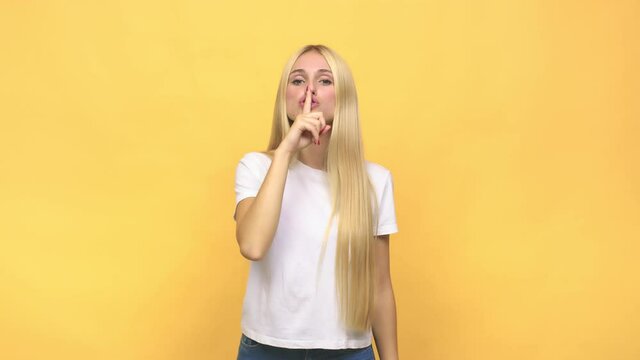 Young caucasian blonde woman keeping a secret or asking for silence