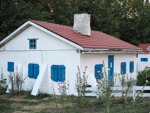 Vintage White House With Blue Shutters And Red Roof