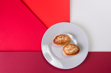 Top view of Two chicken Meatballs served on gray plate. Russian traditional Homemade meat cutlets on colorful abstract red background. Slavic food menu
