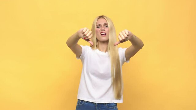 Young caucasian blonde woman showing thumb down and expressing dislike