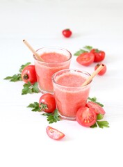strawberry smoothie with mintFresh tomato juice in a glass with bamboo straws on a white background