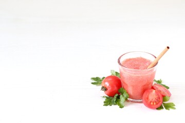 Fresh tomato juice in a glass with bamboo straw on a white background copy space 