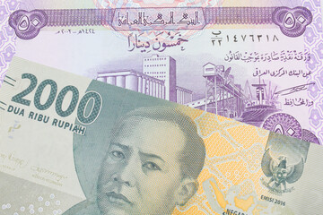 A macro image of a grey two thousand Indonesian rupiah bank note paired up with a purple fifty dinar bill from Iraq.  Shot close up in macro.