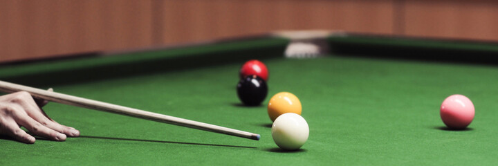 A man's hand playing snooker in a bar Snooker ball on the table. Snooker room background. for...