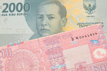 Fototapeta premium A macro image of a grey two thousand Indonesian rupiah bank note paired up with a red ten taka bank note from Bangladesh. Shot close up in macro.