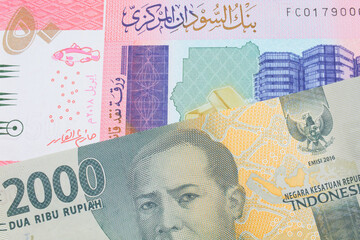 A macro image of a grey two thousand Indonesian rupiah bank note paired up with a colorful fifty pound bank note from Sudan.  Shot close up in macro.