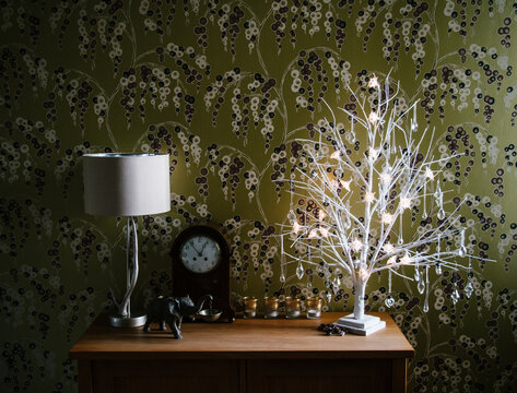 Home interior with white branches decorated with crystal, glass and silver Christmas decorations.
